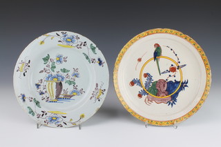An 18th Century English Delft polychrome dish decorated with a parrot sitting on a hoop in a garden landscape enclosed in a geometric border 9", a do. decorated a vase of flowers enclosed in a floral border 9" 