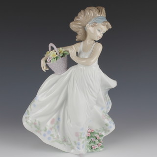 A Lladro figure of a young lady holding a basket of flowers 664 12" 