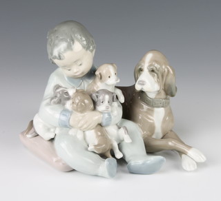 A Lladro group of a young child with a dog and puppies 5456 7"