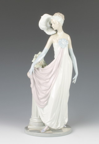 A Lladro figure of a 1920's lady standing by a pedestal 13 1/2" 