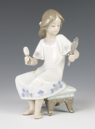 A Lladro figure of a girl sitting on a stool with hair brush and hand mirror 6 1/2" 