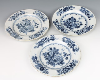 A matched set of three 18th Century English Delft blue and white plates decorated with a vase of flowers enclosed in a border of flowers and motifs 9" 