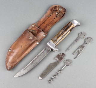 A Skandia German multi-purpose knife with 4 1/2" blade marked Skandia, having a staghorn grip and crossbar marked D.R.G.M 1227103 together with 4 tools - spike, tin opener, corkscrew and file, all contained in a leather scabbard
