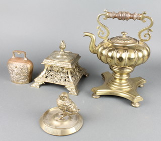 A 19th Century brass match striker in the form of a standing chick raised on a circular base with hinged lid 6" x 3" (no liner), a large and impressive Victorian pierced brass inkwell with hinged lid and associated liner 4" (finial bent), a gilt metal cow bell decorated classical figures 5" (replacement clanger), a melon shaped tea kettle raised on a triform detachable base 8" (holes to lid)