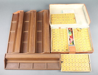 A plastic Mahjong set contained in a leather case together with 4 wooden tile walls 