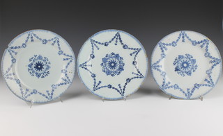A near set of 3 18th Century English Delft blue and white plates decorated with a central floral roundel enclosed in floral swags 9" 