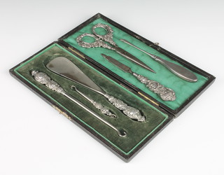 An Edwardian silver cased set of shoe horn, button hook and small hook, a pair of mounted scissors and 2 other implements