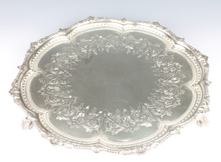 A Victorian silver salver with chased scrolls enclosed in a shell and beaded border on claw and ball feet London 1874 1500 grams, 16" 