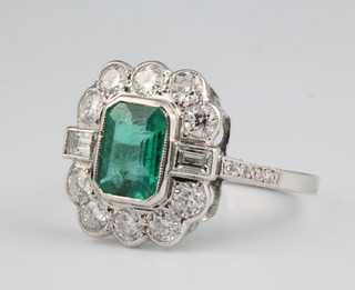An 18ct white gold emerald and diamond Art Deco style ring, the emerald approx. 1.1ct with brilliant and baguette cut diamonds approx. 1.33ct size Q