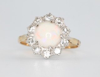 A yellow gold opal and diamond cluster ring, the centre cabochon cut stone surrounded by 10 brilliant cut diamonds, approx 0.7ct size O 1/2