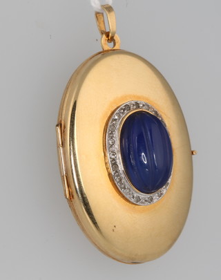 A 9ct yellow gold oval locket with cabochon cut centre stone 