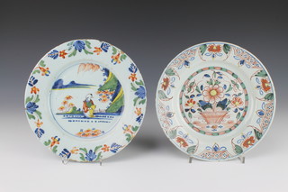 An 18th Century English Delft polychrome plate decorated in the chinoiserie style with a seated gentleman in a garden landscape enclosed in a floral border 9", a do. decorated with a basket of flowers inclosed in a floral border 9" 