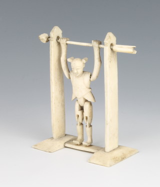 An early 20th century Chinese carved ivory and bone articulated figure of an acrobat on a bar 4"
