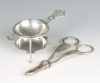 A pair of Victorian silver grape scissors, Sheffield 1898,  a silver tea strainer on stand - the stand 1934 the strainer 1937, 165 grams