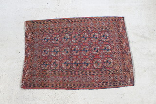 A red and blue ground Tekke Turkoman rug with 21 octagons to the centre 65 1/2" x 47", in wear 