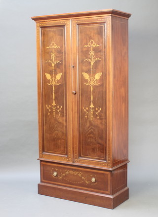 A Victorian inlaid mahogany cabinet with moulded cornice, fitted adjustable shelves enclosed by a pair of panelled doors inlaid torches, the base fitted a drawer inlaid garlands and with brass drop handles 72 1/2"h x 36 1/2"w x 16"d 