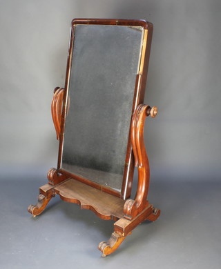 A Victorian arched plate cheval mirror contained in a mahogany swing frame 59"h x 36"w x 24"d at the base 