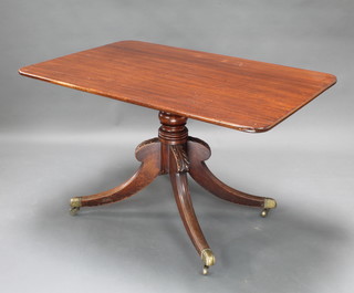 A rectangular Regency mahogany snap top breakfast table raised a turned column with carved tripod base, brass caps and castors 29"h x 50"w x 33"d 