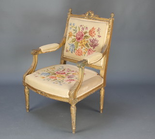 A 19th Century French Empire style gilt painted open armchair with Berlin woolwork seat and back raised on turned and reeded supports  
