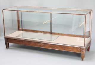 A 1930's rectangular mahogany shop display cabinet fitted a shelf, raised on square supports 36"h x 71"w x 23"d 