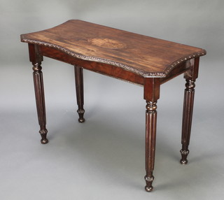 A 19th Century inlaid mahogany side table of serpentine outline with carved apron, raised on turned and reeded supports 29"h x 42"w x 20" (made up) 
 