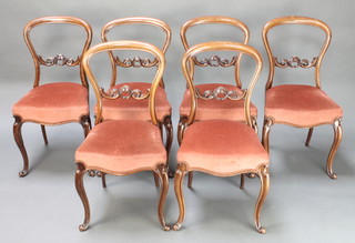 E Winter of 505 New Oxford Street London, a set of 6 Victorian carved and pierced walnut balloon back dining chairs with mid rails, the seats of serpentine outline, raised on cabriole supports 