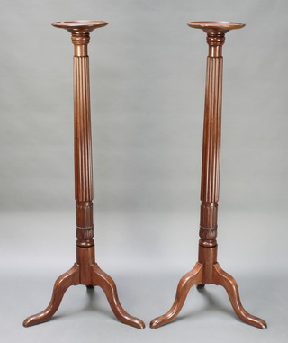 A pair of Georgian style torcheres with circular tops, raised on ring turned columns ending in splayed feet 58"h x 10 1/2" diam. 