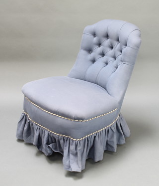 A Victorian nursing chair upholstered in blue buttoned material raised on turned supports 