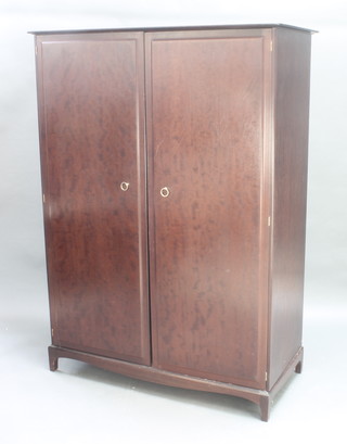 A Stag mahogany wardrobe enclosed by panelled doors, raised on square supports 70" x 51" x 24" 