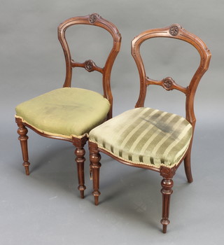 A pair of Victorian carved walnut hoop back chairs with shaped mid rails and over stuffed seats, raised on fluted supports, (old but treated worm) 