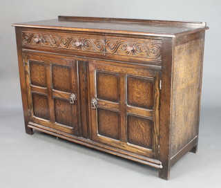 A carved oak sideboard with raised back fitted 3 drawers above double cupboards enclosed by panelled doors 36" x 53" x 20"d 