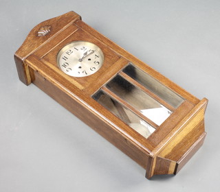 A 1930's striking wall clock with silvered dial and Arabic numerals contained in an oak and bevelled glass case 