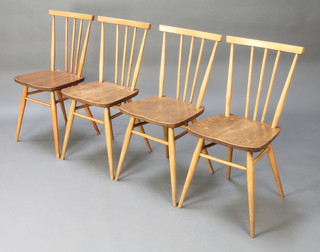 A set of 4 Ercol light elm stick and rail back dining chairs raised on turned supports (some pitting to the seats) 