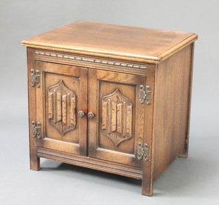 A carved oak cabinet enclosed by panelled doors with linenfold decoration 21" x 22" x 17" 
