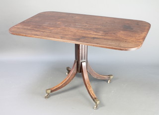 A Victorian breakfast table raised on a chamfered column with tripod base brass caps and casters 28 1/2" x 50" w x 31 1/2"d 