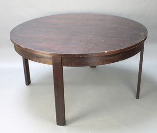 A large circular mahogany finished table raised on 4 plank supports 33"h x 63" diam. 