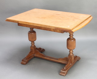 An Art Deco light oak draw leaf dining table raised on cup and cover supports with H framed stretcher 30"h x 47"w x 30"d 