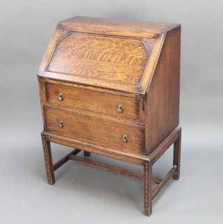A 1930's carved oak bureau, the fall front revealing a well fitted interior above 2 long drawers raised on square tapered supports 41"h x 29"w x 18"d 