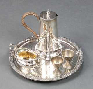 A circular silver plated salver with cast border 11", a twin handled sugar bowl 2", 2 silver plated egg cups and an Art Nouveau cylindrical hot water jug by James Dixon 