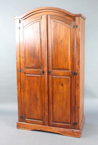 A hardwood finished wardrobe enclosed by a pair of panelled doors, raised on a platform base 75"h x 40"w x 22"d 