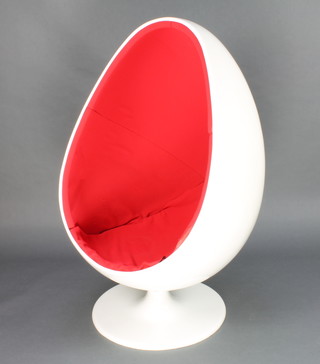 Eero Saarinen, a revolving white pod chair the interior upholstered in red and raised on a spreading foot 59"h x 26"w x31"d