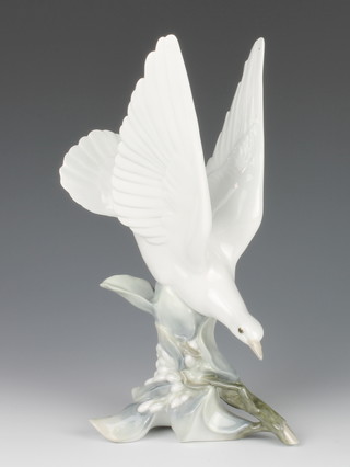 A Lladro figure of a dove sitting amongst flowers 12" 