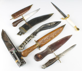 A Wilkinson sword double bladed knife, the 7" blade etched a figure of a standing darts player,  an Indian Kukri with 9" blade and horn grip,  two Indian knives contained in carved hardwood scabbards and 2 other knives