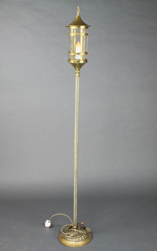 A 1930's brass standard lamp in the form of a candle lantern raised on a brass column with Grecian key decoration, height 60"h x 10"