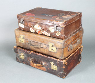 A brown leather suitcase  8"h x 27"x18" d with 1 other case by Cleghon of Edinburgh with brass mounts 8 1/2"h x 28"x 17" and 1 other with chrome lock and numerous luggage labels 7"h x 25"w x 15 1/2"d