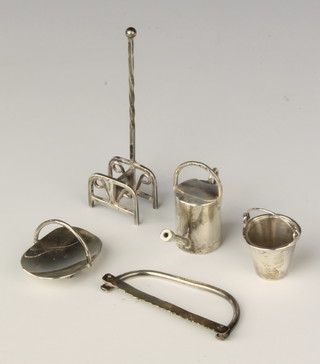 A miniature silver boot scraper, a pail, a basket, watering can and saw, mixed dates all by the maker EVS 44 grams 