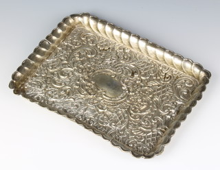An Edwardian repousse silver rectangular dressing table tray with scrolls and flowers and vacant cartouche Birmingham 1903, 212 grams 