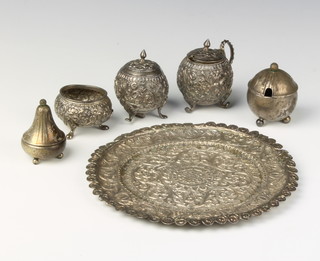 An Indian repousse silver condiment set comprising tray, mustard pot, pepper and salt together with 2 925 silver condiments, 281grams