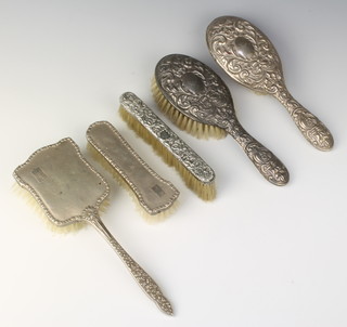 An silver repousse hairbrush, Birmingham 1960 and 4 other brushes