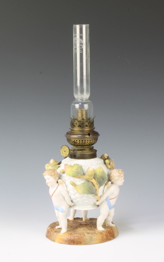 A 19th Century German porcelain oil lamp with acorn decoration supported by 3 cherubs complete with glass chimney, the base impressed 141, 14"h